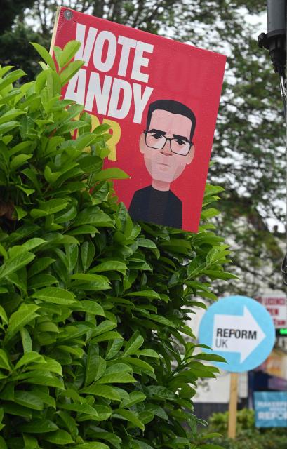 Banners for Labour's Andy Burnham (L) and also the Reform UK political party are pictured in the gardens of residential properties in Ashton-in-Makerfield, west of Manchester in north-west England on June 03, 2026, ahead of the Makerfield by-election. The Makerfield by-election, set to be held on June 18, may see Greater Manchester mayor Andy Burnham return to the government though he would face a tough fight from the poll-topping Reform UK. (Photo by Oli SCARFF / AFP)