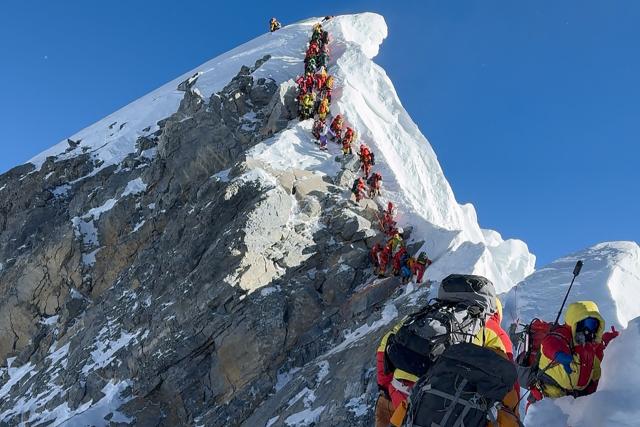 (FILES) This photograph taken on May 20, 2026, shows mountaineers climbing a slope lined up during their ascent from the Hillary Step to summit Mount Everest in Nepal. More than one thousand climbers reached the summit of Mount Everest this season, officials said on June 3, making it the busiest season on record. (Photo by Furte Sherpa / AFP)