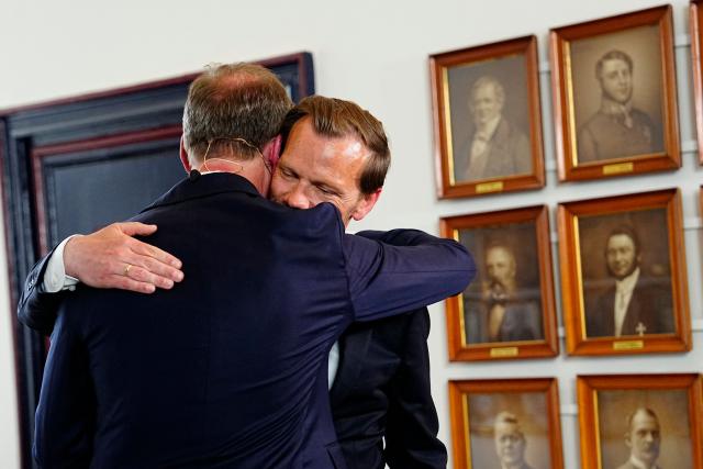 Outgoing Denmark's Ministry of Finance Nicolai Wammen (L) and incoming Denmark's Ministry of Finance Peter Hummelgaard (R) hug during the handover in Copenhagen, Denmark, on June 3, 2026. Following months of talks after inconclusive elections in March 2026, incumbent Frederiksen said on June 1, 2026 she had managed to form a minority government between her Social Democrats, the Socialist People's Party, the centre-left Radikale Venstre and the centrist Moderates. (Photo by Mads Claus Rasmussen / Ritzau Scanpix / AFP) / Denmark OUT