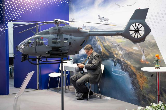 A visitor sits behind of a model of Airbus H145M helicopter during the International Defence, Equipment and Services Exhibition "HEMUS 2026", in Plovdiv on June 3, 2026. The exhibition runs from June 3 to 6 ??? features 216 companies and organizations from 28 countries. (Photo by Nikolay DOYCHINOV / AFP)