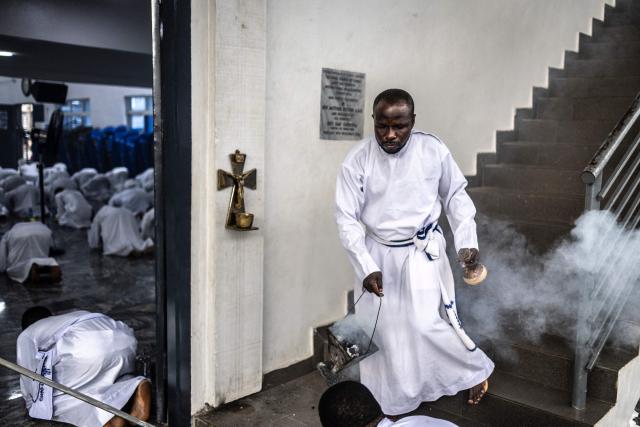 A worshipper burns incense during a service at the Celestial Church of Christ International Headquarters in the Ketu neighbourhood of Lagos, on June 3, 2026. (Photo by OLYMPIA DE MAISMONT / AFP)