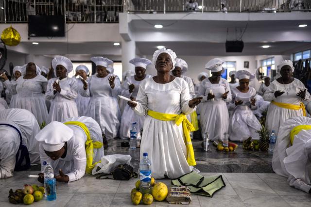 TOPSHOT - A worshipper kneels in prayer beside thanksgiving items during a service at the Celestial Church of Christ International Headquarters in the Ketu neighbourhood of Lagos, on June 3, 2026. (Photo by OLYMPIA DE MAISMONT / AFP)