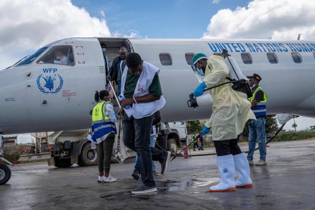 TOPSHOT - A health worker decontaminates a passenger's shoes at Bunia Airport in eastern Democratic Republic of the Congo on June 3, 2026. On May 23, DRC authorities announced the temporary closure of Bunia Airport, located in the capital of Ituri Province, where the 17th Ebola outbreak is raging. The airport reopened on June 2. To date, 48 deaths have been reported among 321 confirmed cases of infection, according to Congolese health authorities and the WHO. (Photo by GLODY MURHABAZI / AFP)