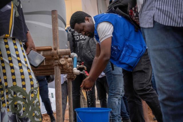 A passenger washes his hands at Bunia Airport in eastern Democratic Republic of the Congo on June 3, 2026. On May 23, DRC authorities announced the temporary closure of Bunia Airport, located in the capital of Ituri Province, where the 17th Ebola outbreak is raging. The airport reopened on June 2. To date, 48 deaths have been reported among 321 confirmed cases of infection, according to Congolese health authorities and the WHO. (Photo by GLODY MURHABAZI / AFP)