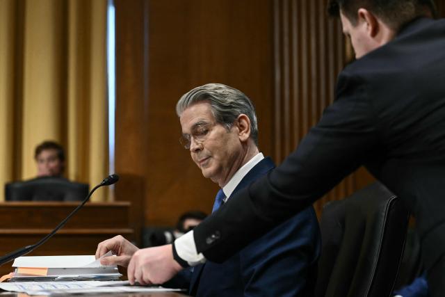 An aide hands a note to US Secretary of Treasury Scott Bessent as he testifies during a Senate Finance Committee hearing concerning the fiscal year 2027 budget for the Treasury Department, on Capitol Hill in Washington, DC, on June 3, 2026. (Photo by Brendan SMIALOWSKI / AFP)