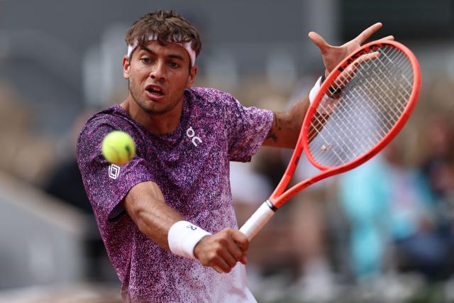Italy's Flavio Cobolli plays a backhand return to Canada's Felix Auger-Aliassime during their men's quarter final singles match on day 11 of the French Open tennis tournament on Court Philippe-Chatrier at the Roland-Garros Complex in Paris on June 3, 2026. (Photo by Anne-Christine POUJOULAT / AFP)