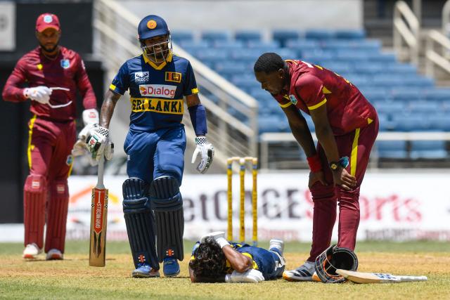 Jayden Seales (R) of West Indies shows concern as Pathum Nissanka (2nd R) of Sri Lanka lies injured on the ground and Kusal Mendis (2nd L) comes to assist during the 1st ODI match between West Indies and Sri Lanka at Sabina Park in Kingston, Jamaica, on June 3, 2026. (Photo by Randy Brooks / AFP)