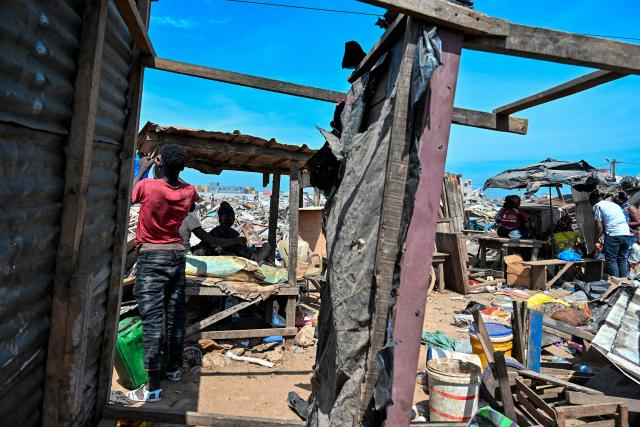 Residents sit under shelters after the destruction of the precarious Zimbabwe neighbourhood during an eviction operation in the Port-Bouet neighbourhood in Abidjan on June 3, 2026. (Photo by Sia KAMBOU / AFP)