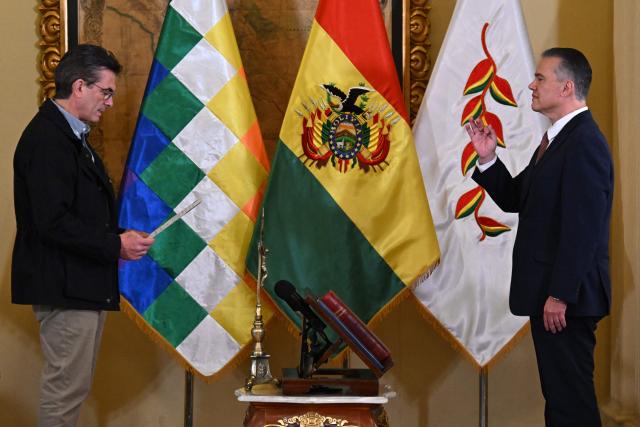 Bolivian President Rodrigo Paz (L) swears in Ernesto Justiniano as Minister of Defense, replacing Marcelo Salinas, during a ceremony at the Government Palace in La Paz, Bolivia, on June 3, 2026. (Photo by Aizar RALDES / AFP)