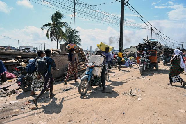 Residents leave with their luggage after the destruction of the precarious Zimbabwe neighbourhood during an eviction operation in the Port-Bouet neighbourhood in Abidjan on June 3, 2026. (Photo by Sia KAMBOU / AFP)