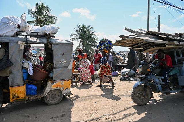 Residents leave with their luggage after the destruction of the precarious Zimbabwe neighbourhood during an eviction operation in the Port-Bouet neighbourhood in Abidjan on June 3, 2026. (Photo by Sia KAMBOU / AFP)