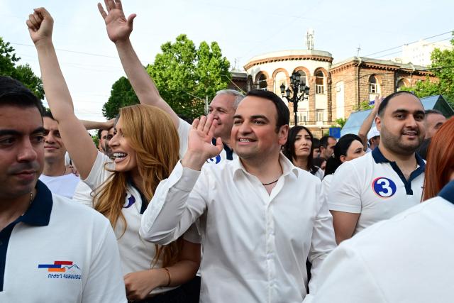 Supporters of Strong Armenia, the party of billionaire Russian-Armenian businessman Samvel Karapetyan - who is under house arrest on charges of plotting a coup, including his nephew Narek Karapetyan (C), stage a campaign march in Yerevan on June 3, 2026, days ahead of the parliamentary elections. (Photo by Karen MINASYAN / AFP)