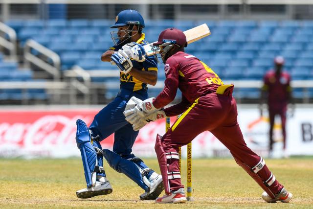 Pavan Rathnayake (L) of Sri Lanka hits the ball as Shai Hope (R) of West Indies looks on during the 1st One Day International (ODI) cricket match between West Indies and Sri Lanka at Sabina Park in Kingston, Jamaica, on June 3, 2026. (Photo by Randy Brooks / AFP)