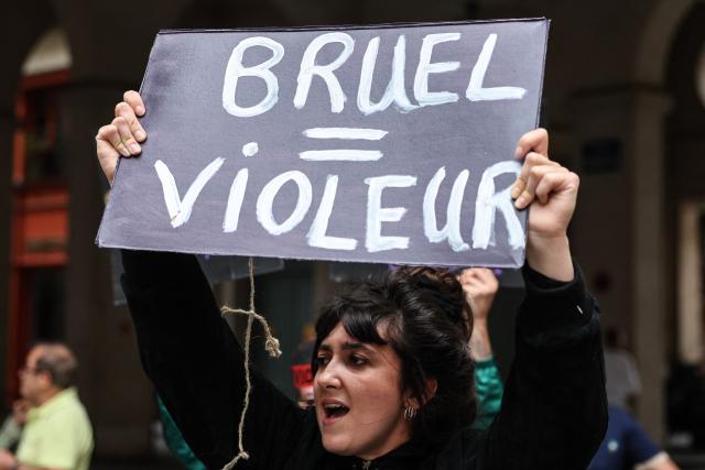 A member of the French feminist collective "NousToutes" (Us all) protests with a placard  reading "Bruel=rapist" outside the Edouard VII theatre to express their anger at the impunity of alleged abusers and call for singer and actor Patrick Bruel to be withdrawn from all stage performances and demanding the complete cancellation of his tour, in Paris, on June 3, 2026. A performance of the play "Deuxieme Partie" was briefly disrupted on the evening of May 27, 2026 in Paris by activists from the feminist collective Nous Toutes who had taken their seats in the Theatre Edouard VII, according to videos posted on social media. Patrick Bruel is currently facing four rape allegations in France and a judicial investigation into sexual assault in Belgium. He denies all the allegations against him. (Photo by Xavier GALIANA / AFP)