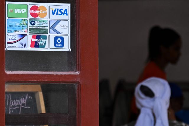 A retail establishment displays various types of bank cards that can be used for payments in Havana on June 3, 2026. Visa and Mastercard payments in Cuba will be suspended from June 7, 2026, after US sanctions prompted a foreign bank to sever ties with a financial institution, Cuba's central bank said on June 3. (Photo by YAMIL LAGE / AFP)
