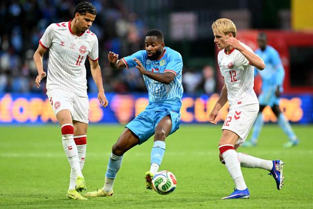 Congo's forward #17 Cedric Bakambu (C) fights for the ball with Denmark's forward #11 William Osula (L) and Denmark's midfielder #12 Victor Froholdt (R) during the international friendly football match between Denmark and DR Congo ahead of the 2026 FIFA World Cup football tournament at the Stade Maurice Dufrasne in Liege on June 3, 2026. (Photo by NICOLAS TUCAT / AFP)