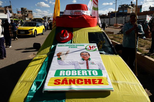 A campaign poster for Peru's presidential candidate for the Juntos por el Peru party, Roberto Sanchez, is displayed on a car during a campaign rally in Juliaca, Peru on June 3, 2026. Right-wing candidate Keiko Fujimori and leftist Roberto Sanchez will face off in Peru's presidential runoff on June 7, 2026. (Photo by Juan Carlos CISNEROS / AFP)