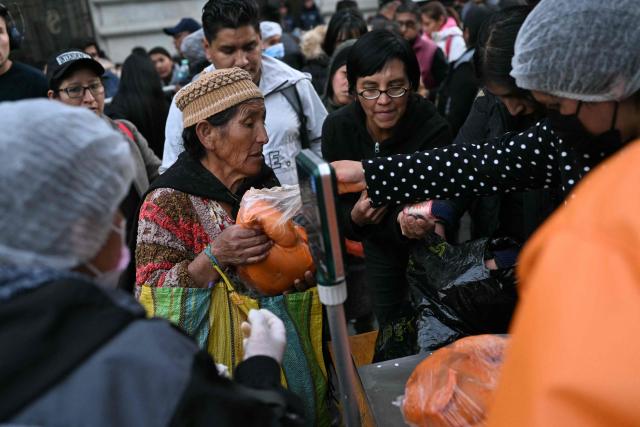 A woman buys a chicken from people selling poultry out of a truck amid food shortages caused by the blockades, in La Paz on June 3, 2026. Hundreds of demonstrators demanded on June 1, in Bolivia’s political capital the resignation of President Rodrigo Paz, as one month of protests and road blockades continues across the country with no solution to the crisis in sight. (Photo by Marvin RECINOS / AFP)
