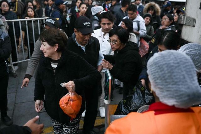 A woman buys a chicken from people selling poultry out of a truck amid food shortages caused by the blockades, in La Paz on June 3, 2026. Hundreds of demonstrators demanded on June 1, in Bolivia’s political capital the resignation of President Rodrigo Paz, as one month of protests and road blockades continues across the country with no solution to the crisis in sight. (Photo by Marvin RECINOS / AFP)