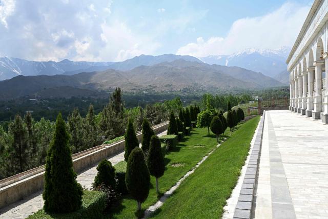 This photograph taken on May 11, 2026 shows the Paghman Hill Castle overlooking a forest against the backdrop of snow-capped mountains in Paghman district, Kabul province. Under the shade of recently planted poplars in northeastern Afghanistan, village leader Ghulam Ali Poya is proud to see residents rediscover the value of trees after years of wartime deforestation from the 1979 Soviet invasion until the fall of the first Taliban government in the early 2000s. Efforts are now underway to revive the landscape in communities across Afghanistan. (Photo by Wakil KOHSAR / AFP)