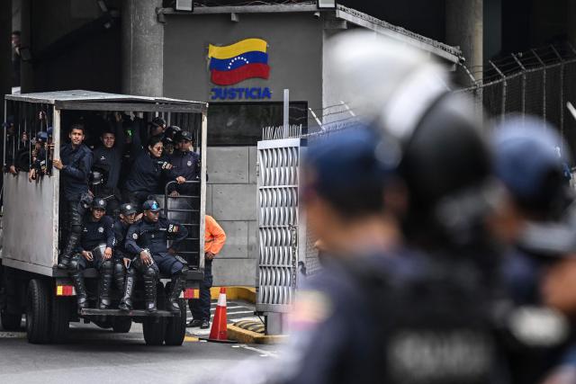 Venezuela's Bolivarian National Police officers guard a prisoners transfer outside El Helicoide prison in Caracas on June 3, 2026. (Photo by Juan BARRETO / AFP)