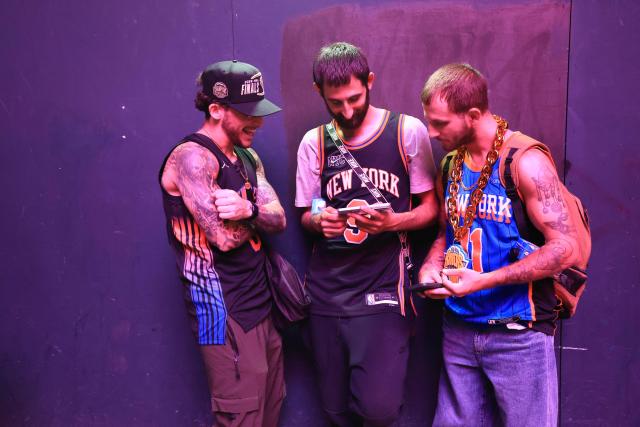 Knicks fans watch Game 1 of the NBA Finals between the New York Knicks and the San Antonio Spurs highlights on their phones in New York City on June 3, 2026. (Photo by TIMOTHY A.CLARY / AFP)