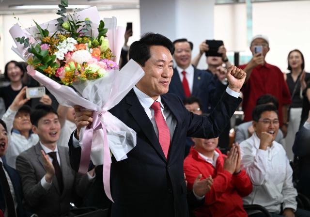 Mayoral candidate Oh Se-hoon (C) of South Korea's main opposition People Power Party celebrates his victory after national TV predicted his win in the local elections at his campaign camp in Seoul on June 4, 2026. (Photo by Jung Yeon-je / AFP)