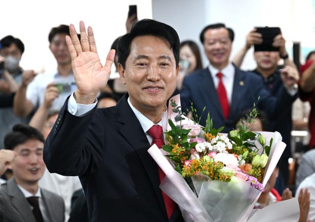 Mayoral candidate Oh Se-hoon (C) of South Korea's main opposition People Power Party celebrates his victory after national TV predicted his win in the local elections at his campaign camp in Seoul on June 4, 2026. (Photo by Jung Yeon-je / AFP)