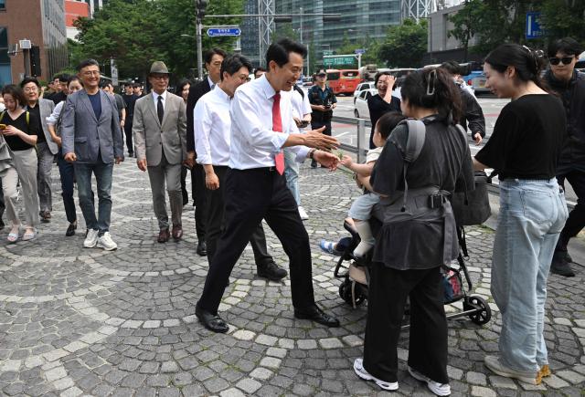 Mayoral candidate Oh Se-hoon (C) of South Korea's main opposition People Power Party greets pedestrians as he walks toward City Hall after national TV predicted his win in the local elections in Seoul on June 4, 2026. (Photo by Jung Yeon-je / AFP)