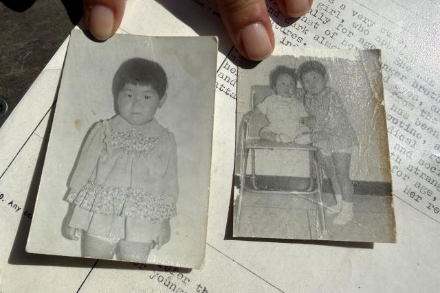 A picture shows black and white photos taken in South Korea of adopted Sofie Randel as a child alone and with her brother, on May 9, 2026 in Kastrup near Copenhagen, Denmark. Eight South Korean adoptees are suing Denmark for its role in their illegal adoptions, demanding the state admit responsibility for violating their right to their identity, origins and family. (Photo by Camille BAS-WOHLERT / AFP)