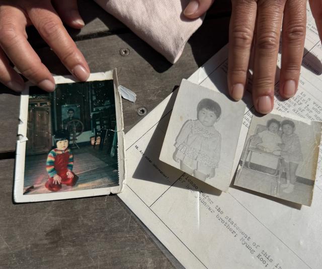 A picture shows black and white photos taken in South Korea of adopted Sofie Randel as a child alone and with her brother, as well as a photo taken after her arrival in Denmark, on May 9, 2026 in Kastrup near Copenhagen, Denmark. Eight South Korean adoptees are suing Denmark for its role in their illegal adoptions, demanding the state admit responsibility for violating their right to their identity, origins and family. (Photo by Camille BAS-WOHLERT / AFP)