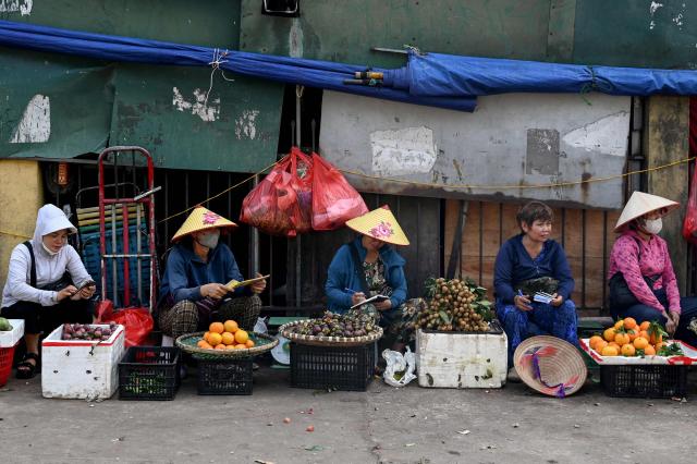 Fruit vendors wait for customers in Hanoi on June 4, 2026. (Photo by Nhac NGUYEN / AFP)