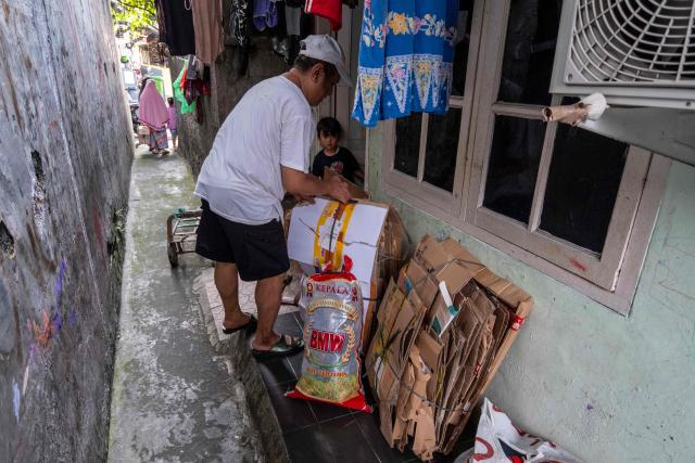 A man prepares household inorganic waste, in the form of cardboard and plastic bottles, to be deposited at a local waste bank in Jakarta on June 4, 2026, as part of instructions issued by Jakarta's Provincial Government that requires residents to separate and sort waste to reduce the capital's mounting waste burden. (Photo by BAY ISMOYO / AFP)