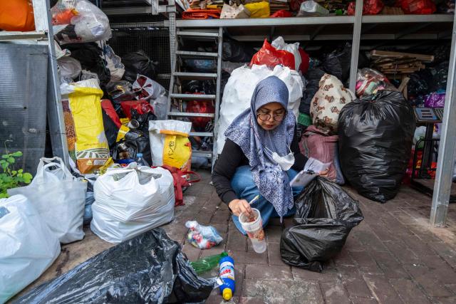 A waste bank employee sorts household inorganic waste, in the form of cardboard and plastic bottles, in Jakarta on June 4, 2026, as part of instructions issued by Jakarta's Provincial Government that requires residents to separate and sort waste to reduce the capital's mounting waste burden. (Photo by BAY ISMOYO / AFP)