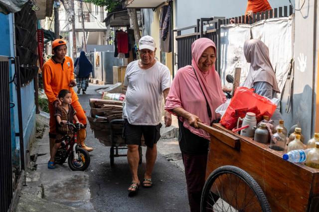 A man delivers household inorganic waste, in the form of cardboard and plastic bottles, to be deposited at a local waste bank in Jakarta on June 4, 2026, as part of instructions issued by Jakarta's Provincial Government that requires residents to separate and sort waste to reduce the capital's mounting waste burden. (Photo by BAY ISMOYO / AFP)