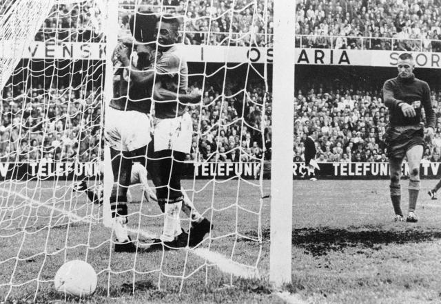 (FILES) Brazilian forward Pele (C) congratulates his teammate Vava (20) after he scored a goal as Swedish goalkeeper Karl Svensson reacts on June 28, 1958 in Stockholm during the World Cup final between Brazil and Sweden. Vava and Pele scored two goals each as Brazil won its first title beating World Cup host Sweden 5-2. From the artistry of Pele to Maradona's "Hand of God", Zidane's headbutt and the clash between France's Battiston against Germany's Schumacher... Heroic, historic, dramatic, bizarre, spectacular, jubilantthe glorious history of the World Cup is full of unforgettable moments. (Photo by AFP)