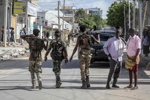 TOPSHOT - Somali government forces patrol a street as residents gather following reported shelling in the Howl Wadaag district of Mogadishu, on June 4, 2026. Heavy gunfire was heard through the night in Somalia's capital and smoke was rising over the city, AFP journalists reported on June 4, 2026, as planned protests turned into pitched battles between political factions.  
Somalia has fallen into a new political crisis after President Hassan Sheikh Mohamud announced that his term, due to expire on May 15, had been extended for a year.
The opposition and regional leaders have rejected the move and demonstrations were due to take place on Thursday. (Photo by AFP)