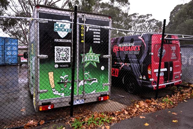 Two vans from the Melbourne Stars and Melbourne Renegades cricket Big Bash League (BBL) teams sit in a compound in Melbourne on June 4, 2026. Melbourne's two Big Bash League sides -- the Stars and the Renegades -- are set to merge into a single Twenty20 franchise, but the move has sparked "confusion, uncertainty and anxiety" among players. Cricket Victoria's plan unveiled on June 3, will see the Melbourne Stars retained by the state governing body but rebranded and the Melbourne Renegades sold entirely to private investors. (Photo by William WEST / AFP)