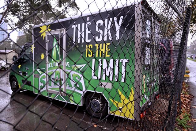 Two vans from the Melbourne Stars and Melbourne Renegades cricket Big Bash League (BBL) teams sit in a compound in Melbourne on June 4, 2026. Melbourne's two Big Bash League sides -- the Stars and the Renegades -- are set to merge into a single Twenty20 franchise, but the move has sparked "confusion, uncertainty and anxiety" among players. Cricket Victoria's plan unveiled on June 3, will see the Melbourne Stars retained by the state governing body but rebranded and the Melbourne Renegades sold entirely to private investors. (Photo by William WEST / AFP)