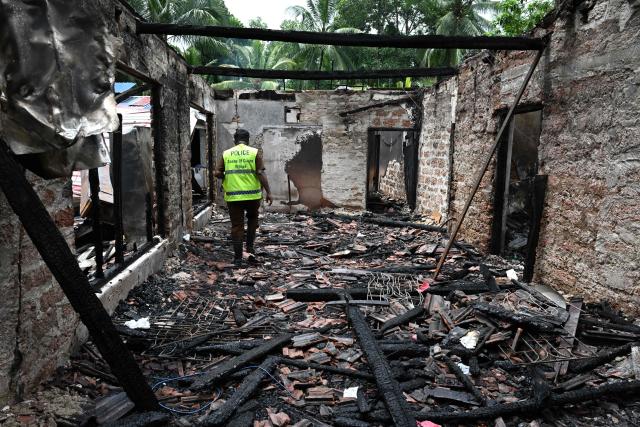 A Sri Lankan Scene of Crime Officer (SOCO) inspects the burnt house a day after a fire broke out at an elder care home in Batagoda on June 4, 2026. The manager of a Sri Lankan care home was arrested June 4, a day after a fire killed 12 residents and injured six others, officials said. (Photo by Ishara S. KODIKARA / AFP)