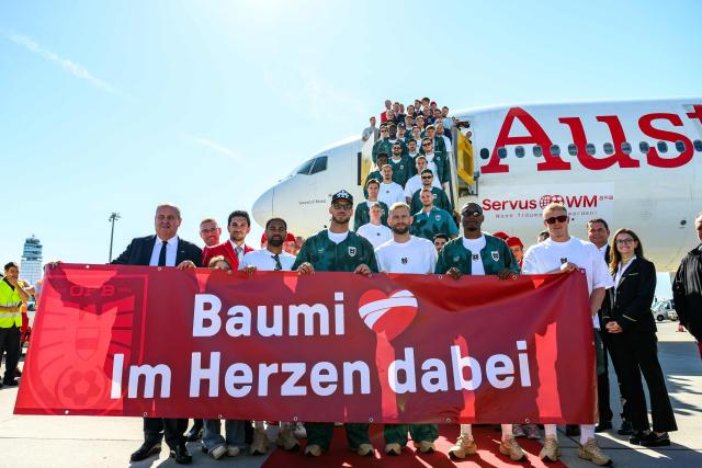 Members of Austria's national football team hold a banner reading "Baumi - with us in our hearts", addressing injured team player Christoph Baumgartner nicknamed "Baumi" who will miss the World Cup due to injury, as the team boards a plane before departing from the Schwechat airport near Vienna, Austria, on June 4, 2026, ahead of the FIFA 2026 World Cup. (Photo by MAX SLOVENCIK / APA / AFP) / Austria OUT