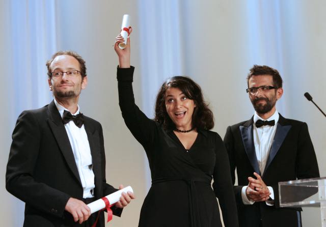 (FILES) Iranian cartoonist Marjane Satrapi (C) celebrates 27 May 2007 next to French director Vincent Paronnaud (R) after equally winning with Mexican director Carlos Reygadas (L) the Grand Jury prize for the animated film 'Persepolis' during the Closing ceremony of the 60th edition of the Cannes Film Festival at the Festival Palace in Cannes, southern France. 22 are in competition for the Palme d'Or top prize 27 May. The Franco-Iranian artist Marjane Satrapi, who gained worldwide recognition with the graphic novel and film "Persepolis," has died at the age of 56, AFP learned on June 4, 2026 from her relatives. (Photo by VALERY HACHE / AFP)