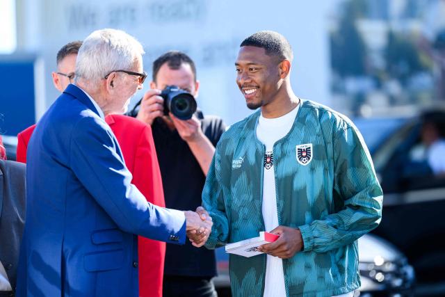 Austria's President Alexander Van der Bellen (L) shakes hands with Austria's national football team player David Alaba (R) as the team arrives to board a plane before the team departed from the Schwechat airport near Vienna, Austria, on June 4, 2026, ahead of the FIFA 2026 World Cup. (Photo by MAX SLOVENCIK / APA / AFP) / Austria OUT