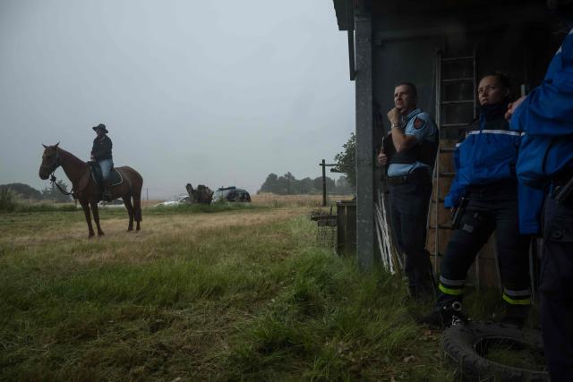 Police officers stand next to an equestrian centre manager on horseback as they prepare to continue the search for 11-year-old Lyhanna who went missing on May 29 after getting into a man's car in front of her middle school in the town of Fleurance, west of Toulouse, on June 4, 2026. A 41 year-old suspect, father of one of Lyhanna's friends, who, prior to her disappearance, had been the subject of several reports and complaints, notably for the rape of a minor, was formally charged on June 1 with kidnapping and false imprisonment, and placed in custody. (Photo by Ed JONES / AFP)