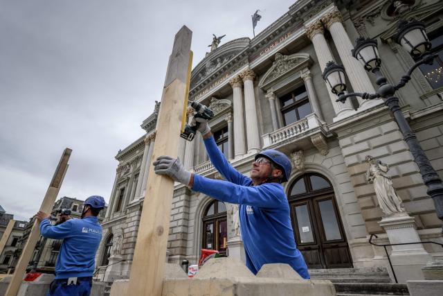 Workers install a wooden barricade around the Grand Theatre de Geneve to protect its facade ahead of demonstrations against the G7 summit in nearby Evian, in Geneva, on June 4, 2026. Protests against the G7 summit in Evian are set to take place in nearby Geneva, where activists can gather more easily than in the tightly secured host town. (Photo by Fabrice COFFRINI / AFP)