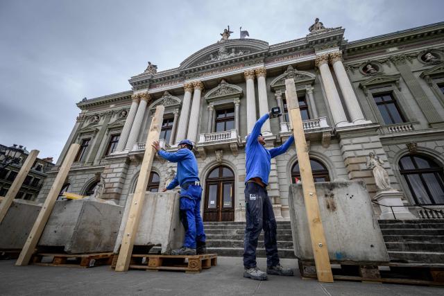 Workers install a wooden barricade around the Grand Theatre de Geneve to protect its facade ahead of demonstrations against the G7 summit in nearby Evian, in Geneva, on June 4, 2026. Protests against the G7 summit in Evian are set to take place in nearby Geneva, where activists can gather more easily than in the tightly secured host town. (Photo by Fabrice COFFRINI / AFP)