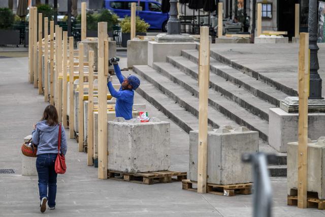 A workers installs a wooden barricade around the Grand Theatre de Geneve to protect its facade ahead of demonstrations against the G7 summit in nearby Evian, in Geneva, on June 4, 2026. Protests against the G7 summit in Evian are set to take place in nearby Geneva, where activists can gather more easily than in the tightly secured host town. (Photo by Fabrice COFFRINI / AFP)