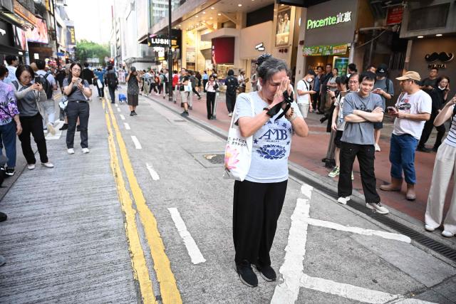 Former activist Lui Yuk-lin (C) pays her respects near Victoria Park in the Causeway Bay district of Hong Kong on June 4, 2026, where people gathered annually on June 4 to mourn the victims of China's Tiananmen Square crackdown in 1989, a tradition now banned following a national security law imposed on the city in 2020. (Photo by Peter PARKS / AFP)