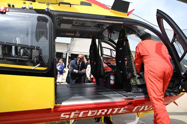 France's Interior Minister Laurent Nunez (C) inspects a civil security helicopter at the Nimes-Garons civil security air base during a trip in the Gard and Bouches-du-Rhone regions focused on organized crime and the launch of the national wildfire prevention campaign in Nimes, southern France on June 4, 2026. (Photo by Miguel MEDINA / POOL / AFP)