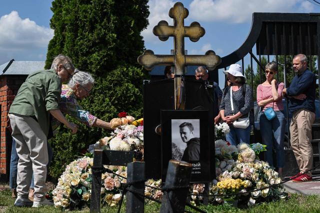 People lay flowers at the grave of the late Russian opposition leader Alexei Navalny to mark his 50th birthday at the Borisovo cemetery in Moscow on June 4, 2026. (Photo by Igor IVANKO / AFP) / NAVALNY HAS BEEN DECLARED "EXTREMIST" BY RUSSIAN AUTHORITIES. IN RUSSIA, ANYBODY WHO MENTIONS NAVALNY OR HIS ANTI-CORRUPTION FOUNDATION WITHOUT STATING THAT THEY HAVE BEEN DECLARED "EXTREMIST" IS SUBJECT TO FINES OR UP TO FOUR YEARS IN PRISON FOR REPEATED OFFENCES.